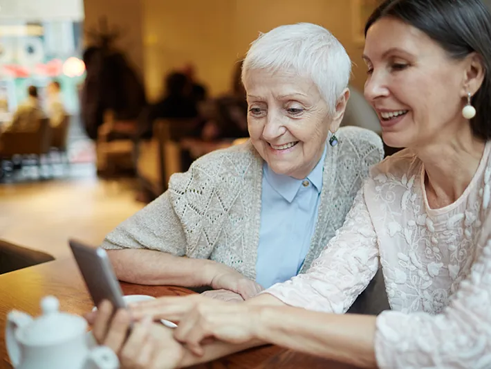 Two women reviewing benefits information on a tablet